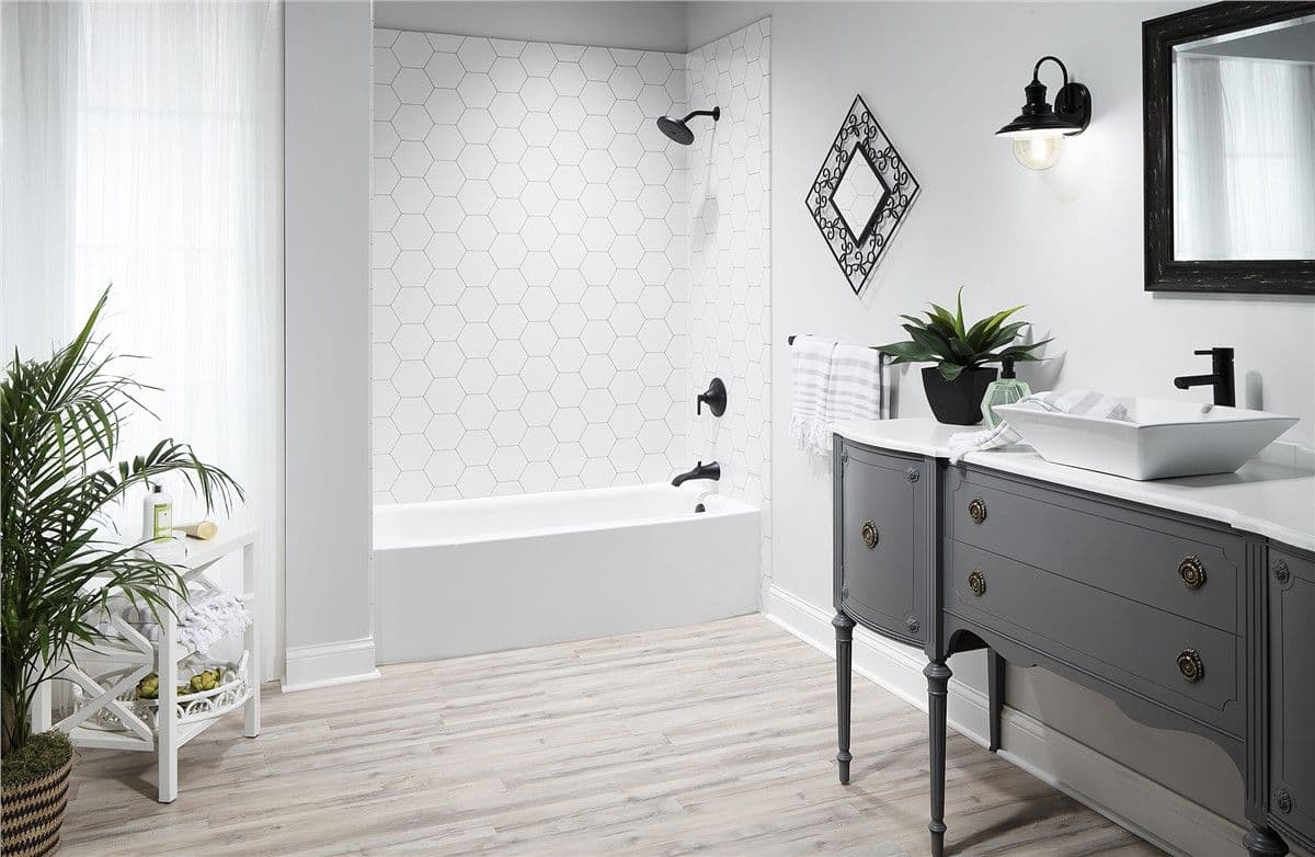 A white and gray bathroom with combination shower tub with hexagonal tiles and black fixtures.